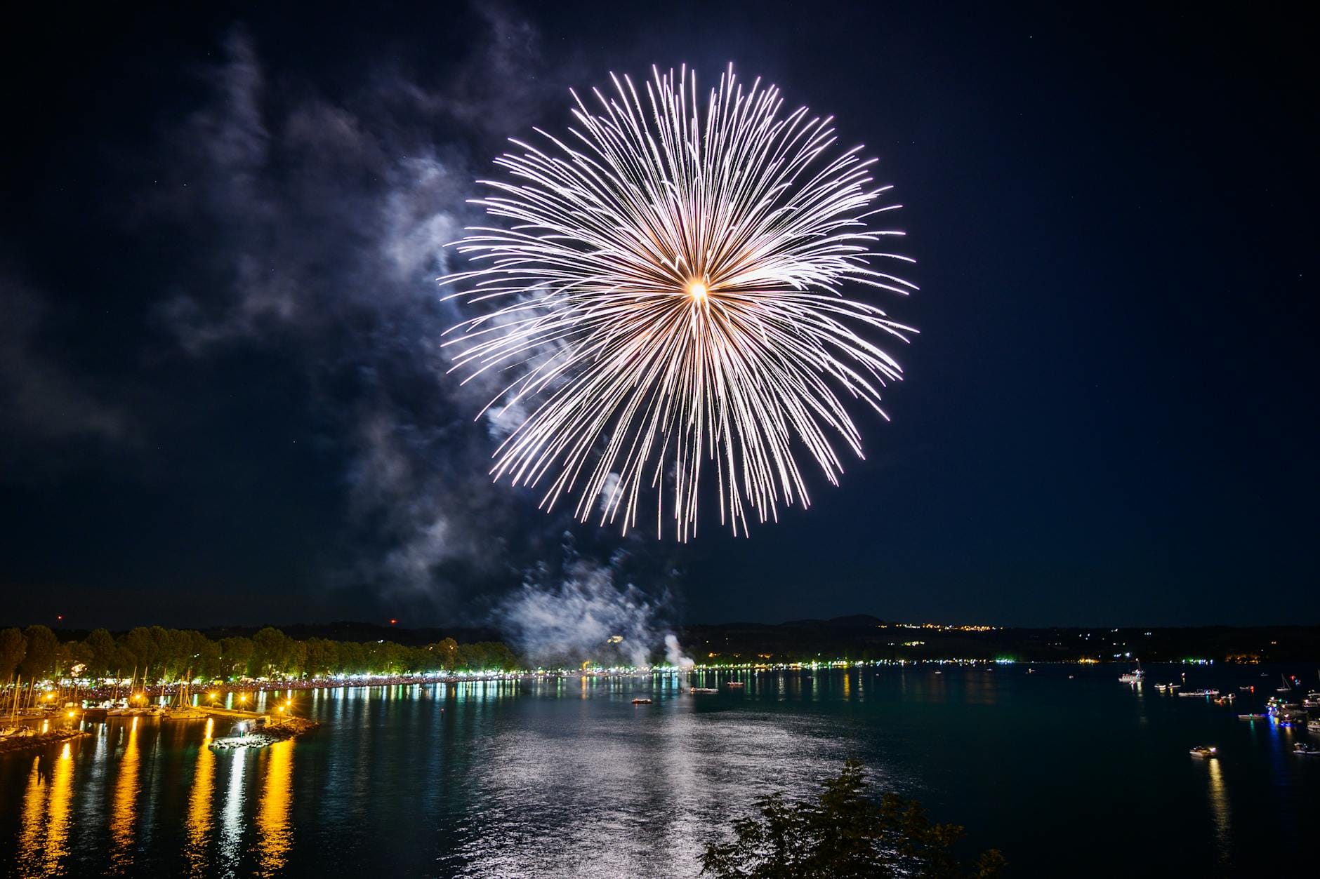 Fajerwerki nad nocnym jeziorem podczas świętowania niepodległości