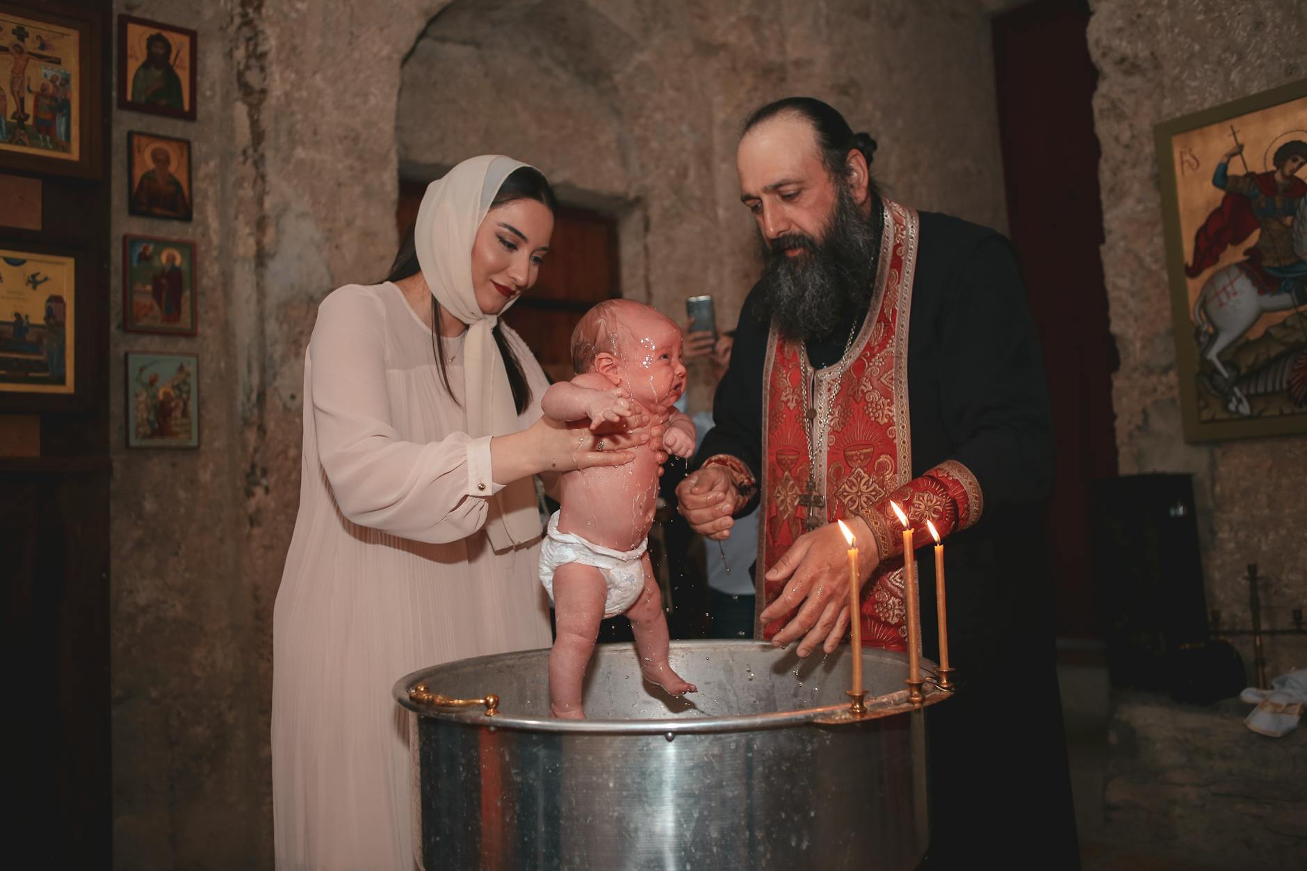 Rodzinna ceremonia chrztu w cerkwi z udziałem prawosławnego księdza
