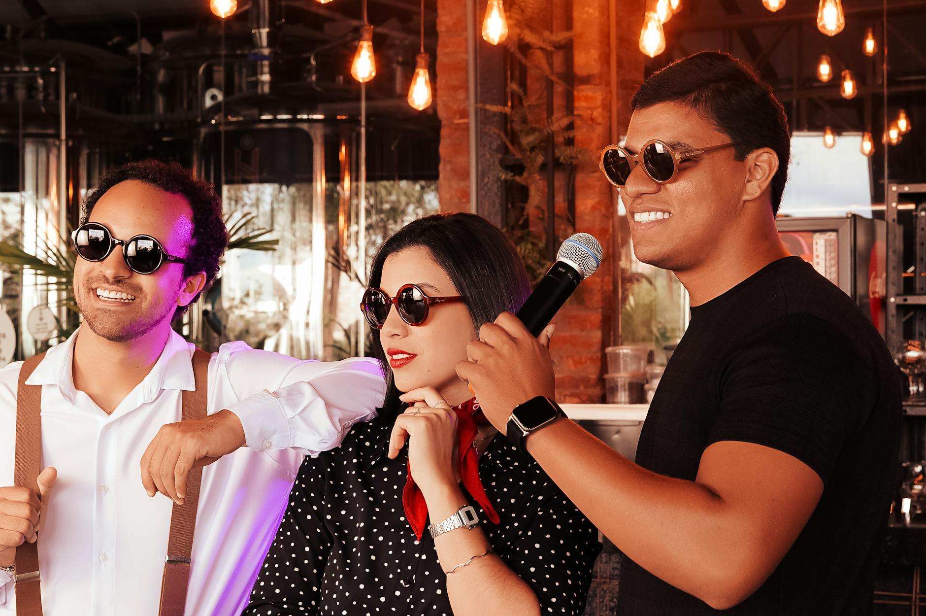 Trójka przyjaciół śpiewa karaoke w salonie przy ciepłym, nastrojowym świetle