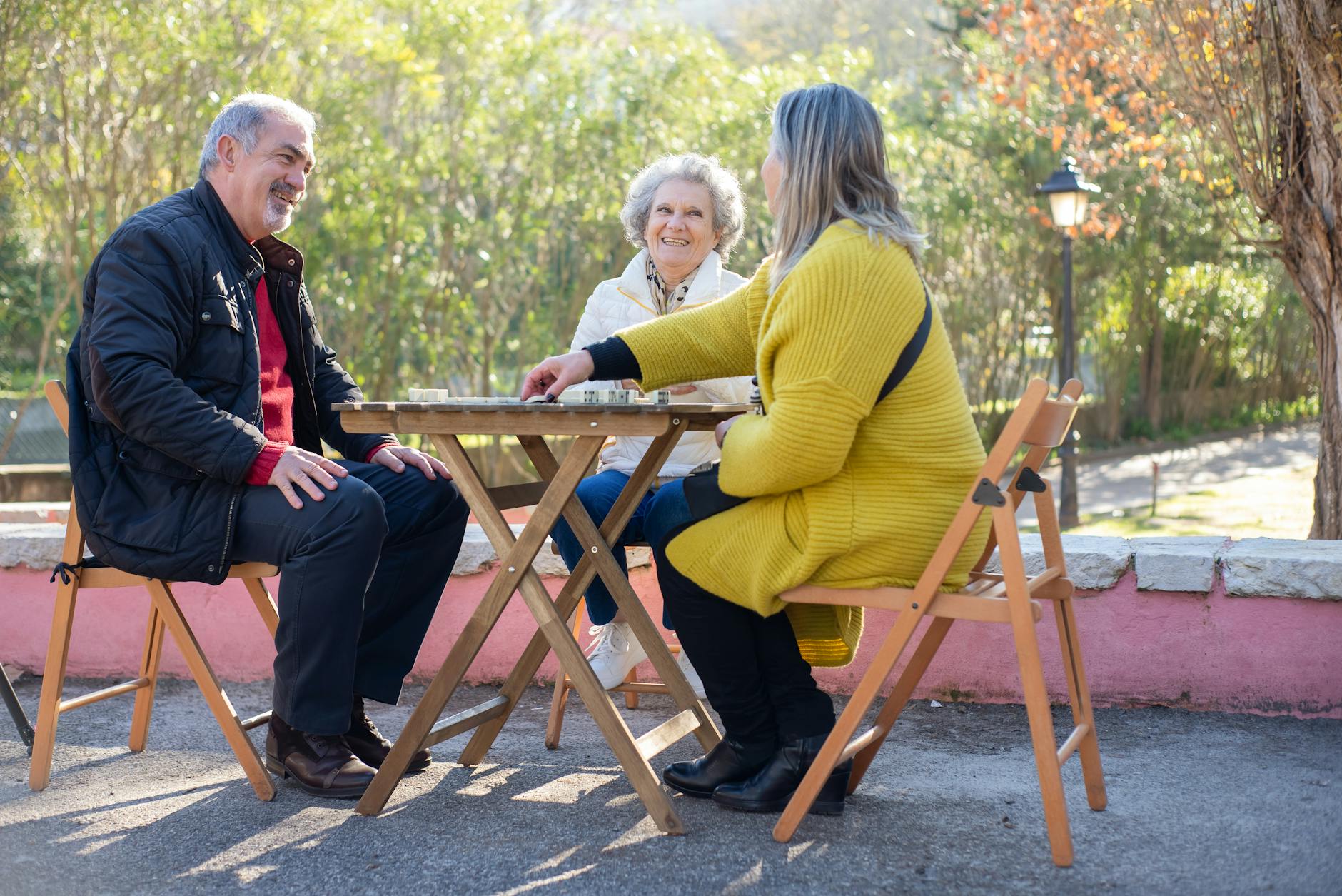 Dorośli sąsiedzi grają w planszówkę na świeżym powietrzu w parku