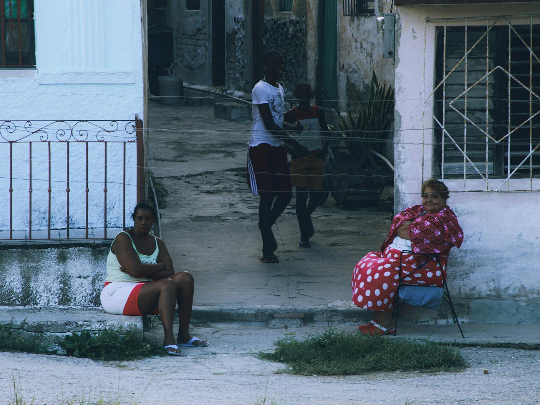 Dwie sąsiadki siedzą na rogu ulicy na osiedlu, rozmawiają i odpoczywają