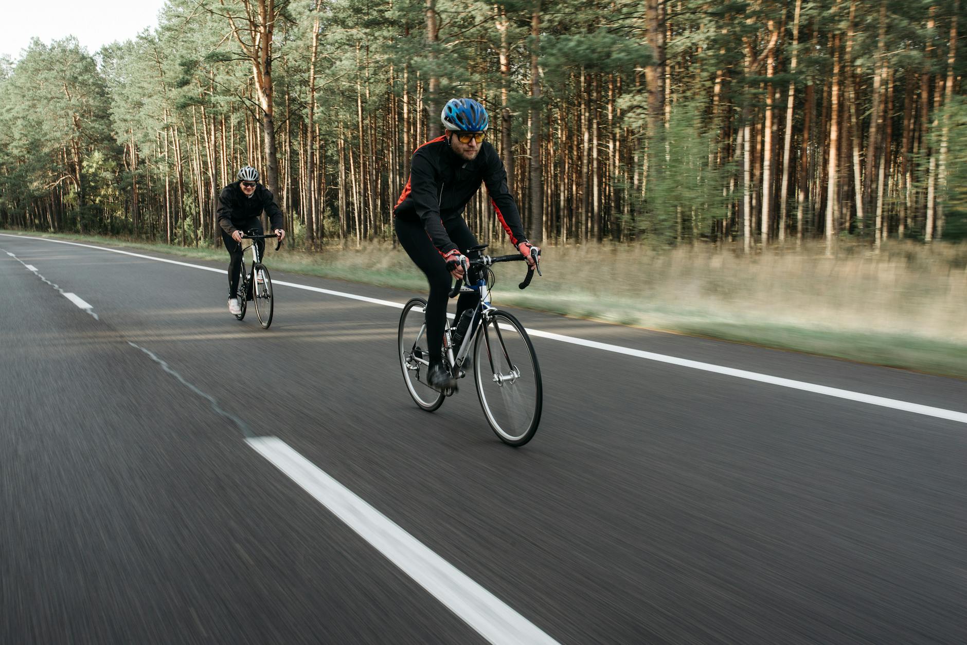 Dwóch rowerzystów jedzie leśną drogą podczas rekreacyjnej wycieczki