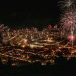 Nocne fajerwerki nad oświetlonym miastem podczas świętowania Nowego Roku