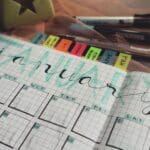 Ręcznie wypełniony planner na styczeń z długopisami na biurku